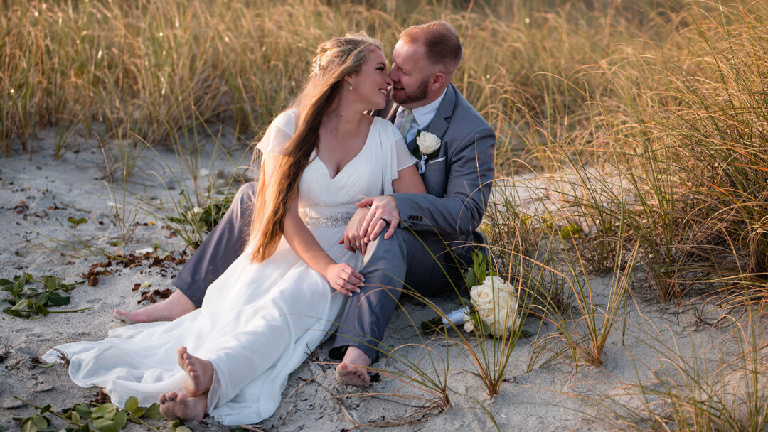 When to apply for your marriage license. Photo showing bride and groom sitting on beach